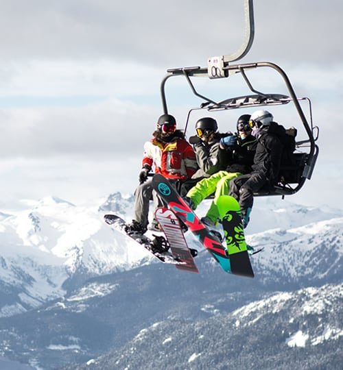Four snowboarders on a ski lift.