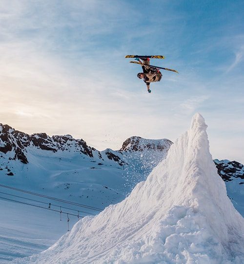 Skier jumping over a snow mound.